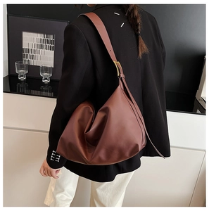 Detail of caramel brown hobo tote with wide shoulder strap and gold metallic buckle