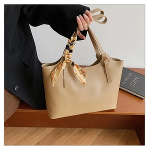 Detail of khaki faux leather tote bag with elegant floral scarf handle and adjustable strap
