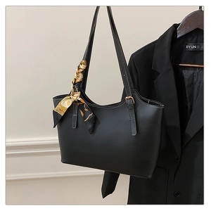 Detail of black matte leather tote bag with vintage silk scarf and office blazer accessory