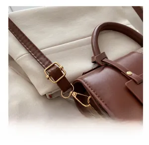 Nahaufnahme der braunen Lederhandtasche mit goldener Schnalle und Gurt-Details
