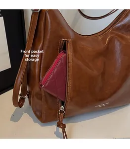 Detail of brown leather tote bag with front zipper pocket for small wallet storage