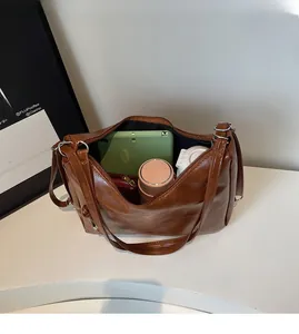 Top view of spacious interior of brown vintage tote bag filled with daily essentials