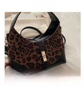 Detail view of leopard and rose print handbag with black leather and gold metal clasp