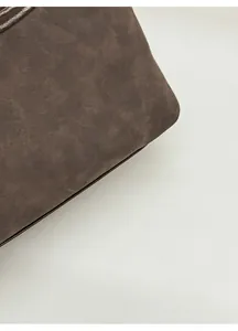 Gros plan du sac bandoulière en daim marron avec le logo Fashion & Bags imprimé
