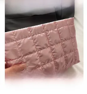 Close-up of pink quilted satin toiletry bag showing soft fabric and stitched pattern