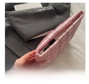 Detail of a smooth black metal zipper on a pink quilted satin makeup bag and pouch