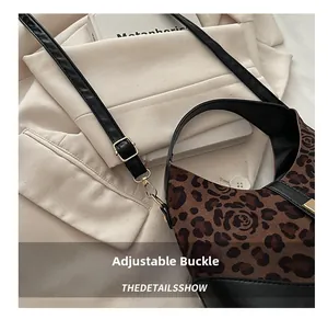 Detail of adjustable shoulder strap with gold metal buckle on leopard print handbag
