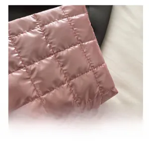 Detailed view of pink quilted fabric with pleated texture and soft pearlescent finish