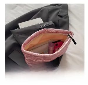 Pink quilted silk makeup bag showing interior storage for lipstick and phone
