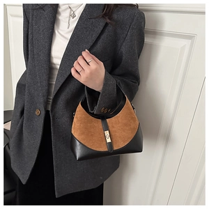 Detail of vintage two-tone bucket bag in brown suede and black leather texture
