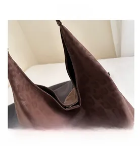 Detalle macro de bolsa tote con estampado de leopardo marrón, textura de tela y asas