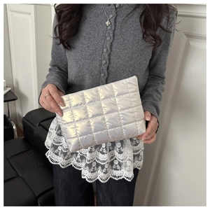 Close-up of a silver quilted fashion clutch with metallic finish and grid pattern