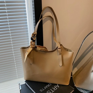 Minimalist beige faux leather tote bag with elegant silk scarf on handle for women