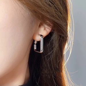 Élégantes boucles d'oreilles créoles rectangulaires en argent portées par un modèle