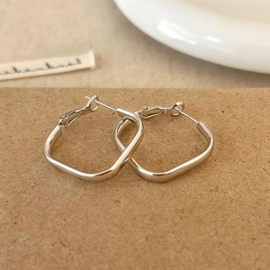 Vue détaillée de boucles d'oreilles géométriques carrées en argent sur carte