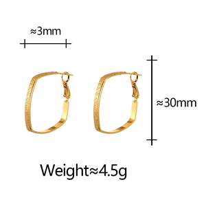 Detail view of gold geometric hoop earrings showing size dimensions and matte texture