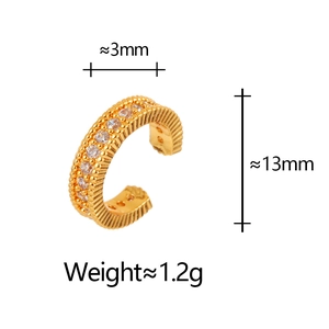 Elegant gold ear cuff with zircon inlay and ribbed texture on white background
