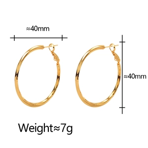 Close-up of gold hoop earrings showing 40mm diameter measurement and 7g weight details