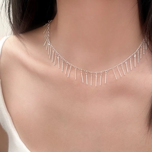 Collier ras de cou argenté à franges avec breloques en métal poli sur un mannequin