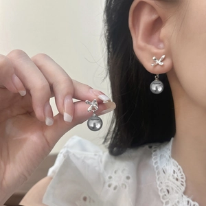 Detailed view of elegant silver bow earrings with round grey pearl pendants for women