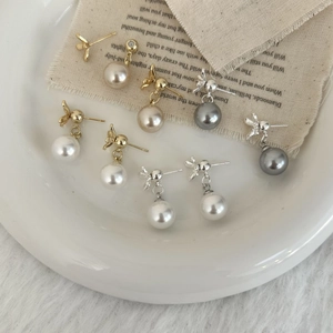 Elegant pearl stud earrings with bow design in white, champagne and grey colors