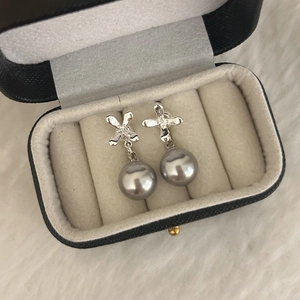 Detailed view of elegant flower pearl earrings in a luxury jewelry gift box