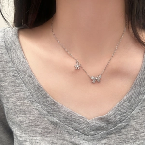 Collier élégant avec nœud et fleur serti de zircons brillants porté par une femme