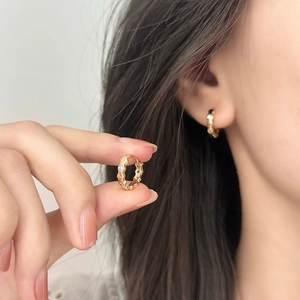 Eleganti orecchini a cerchio ondulati dorati con zirconi incastonati per un look minimalista