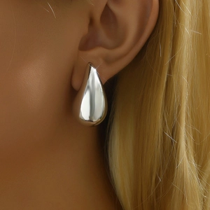 Boucles d'oreilles minimalistes gouttes d'eau en argent poli portées par un mannequin