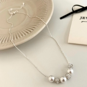 Elegant silver necklace with three white pearls and three crystal balls on a delicate chain