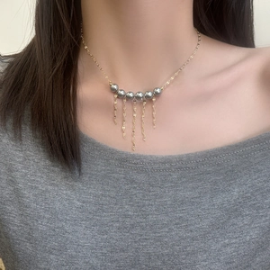 Collier vintage français élégant avec perles grises et franges dorées sur mannequin
