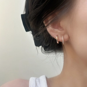 Créoles chic en or rose et ensemble serti de zircons portés par un mannequin femme