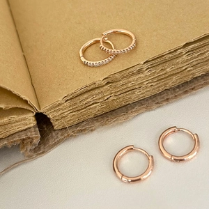 Détail du lot de créoles en or rose comprenant une paire polie et une avec oxydes de zirconium