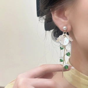 Elegant pearl and crystal petal tassel earrings with long green beads on model