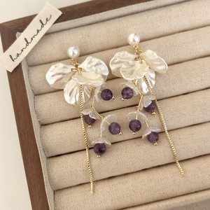Detail of floral tassel earrings with pearl studs and purple crystal beads in a gift box