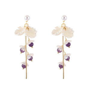 Detail of floral tassel earrings with white resin petals and purple bellflower beads