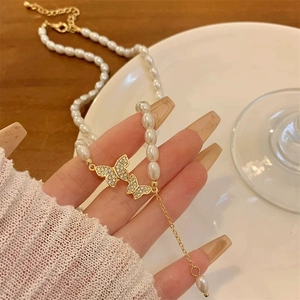 Collier élégant en perles avec pendentif double papillon doré serti de zircons