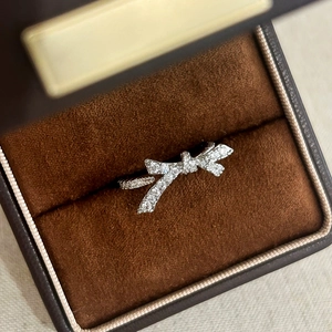 Vue macro d'une bague nœud argentée sertie de zircons dans un écrin à bijoux en velours