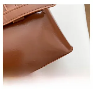 Nahaufnahme der karamellbraunen Kunstleder-Handtasche mit feiner Naht und Glanz-Textur