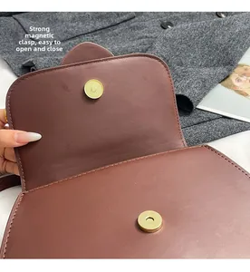 Detail of strong magnetic snap closures on the vintage dark brown leather shoulder bag