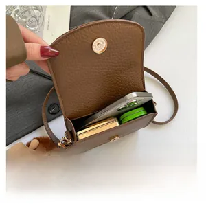 Internal view of brown litchi pattern leather bag with phone and compact powder