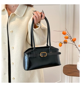 Detail der schwarzen Leder-Schultertasche mit goldener Schnalle und Retro-Design