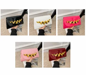 Detail of evening clutches in five colors with artistic gold wavy metal buckles