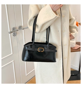 Details der schwarzen Lackleder-Schultertasche mit goldener Schnalle und Riemen