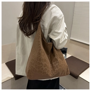 Detail of large brown leopard print tote bag with soft suede texture and slouchy design