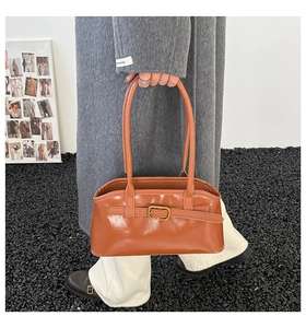 Details der karamellfarbenen Vintage-Schultertasche mit Metallschnalle und glatter Textur