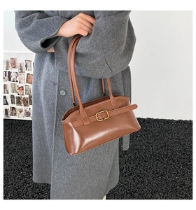 Braune glänzende Leder-Schultertasche mit Schnallendetail zum grauen Wollmantel
