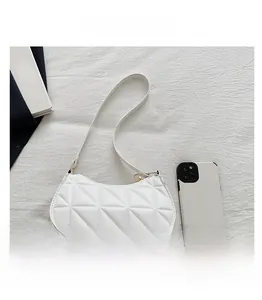 Vue de dessus d'un sac à bandoulière matelassé blanc à côté d'un smartphone pour la taille