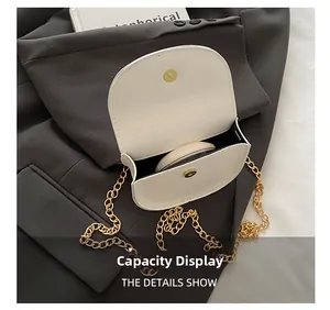 Mini white chain bag with gold buckle showing interior capacity for makeup items
