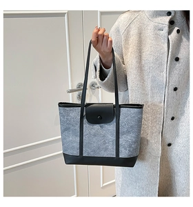 Détail du sac cabas en feutre gris avec rabat en cuir noir et fermeture à bouton